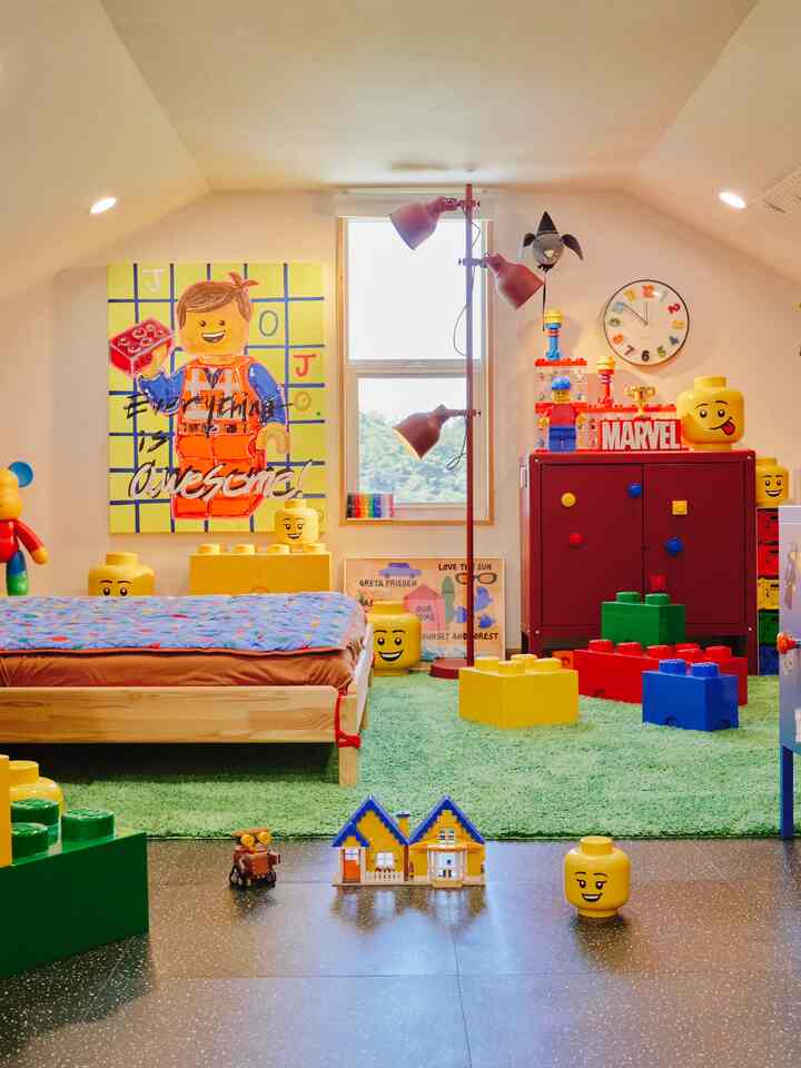 鮮やかな黄色と赤、緑の色調が映えるロフトの子供部屋、レゴの小物と子供用ベッドが配置された楽しい雰囲気のインテリア