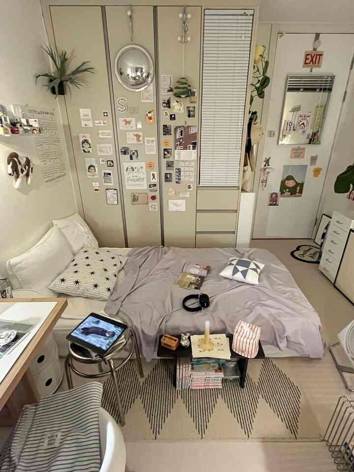 アイボリーとベージュの色調の3坪寝室、中央に掛け布団カバーのあるベッドとスツール、壁に設置されたクローゼットが配置された温かみのある空間