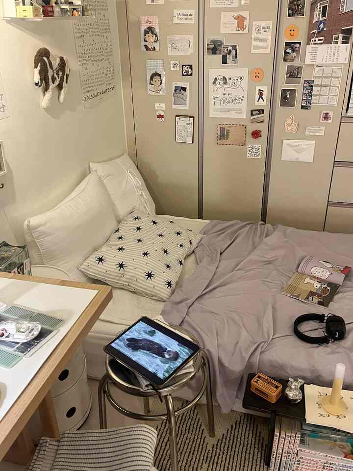 白とベージュの色調の寝室、スツールとデスクが配置された落ち着いた空間