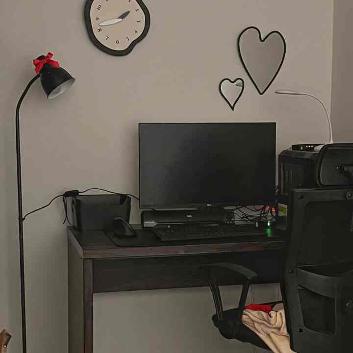 Black and white tone home office featuring a modern desk and chair, floor lamp, and heart-shaped mirrors with a neat atmosphere