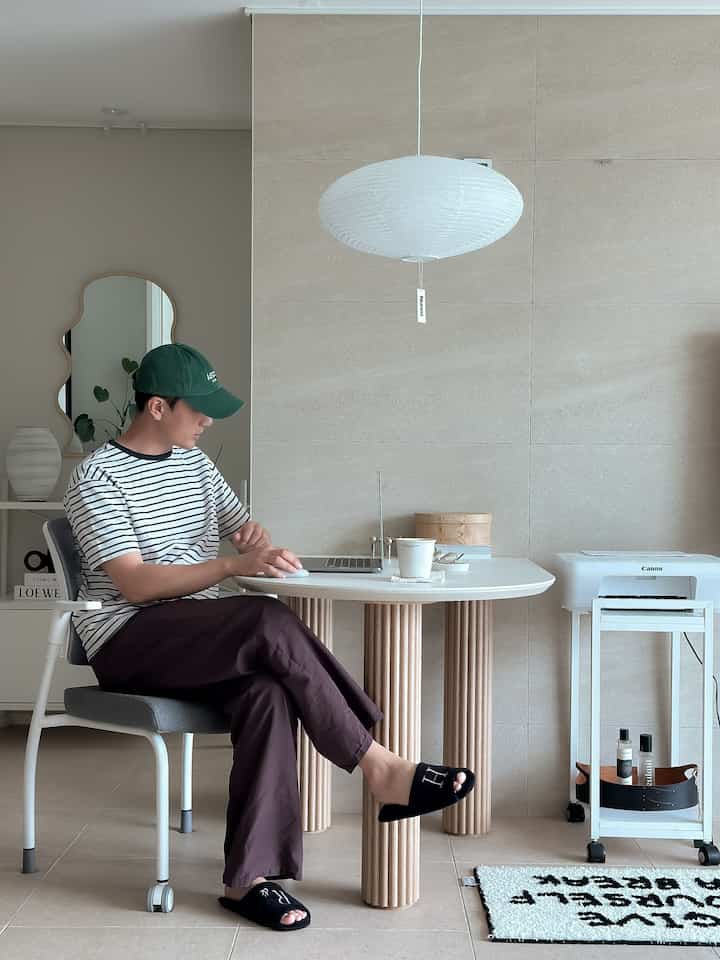 ホワイトとグレーのトーンが特徴のホームオフィス、シンプルなデスクと複合機、快適なチェアが配置されたモダンな雰囲気