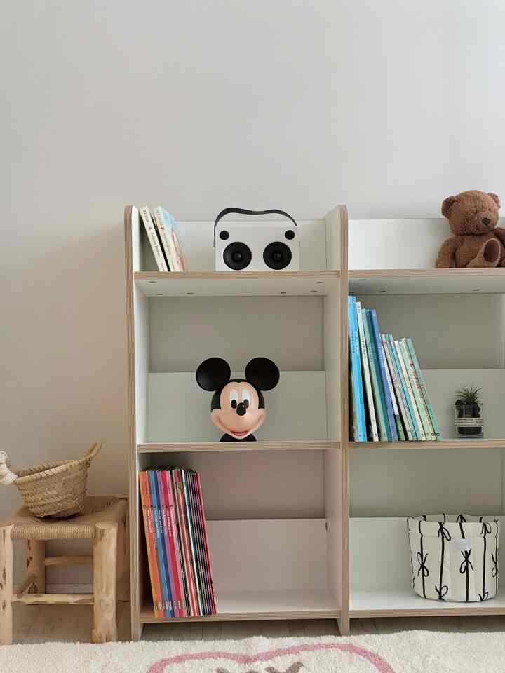 Natural-colored kids' room featuring bookshelves with baby toys and children's books in a cozy setting