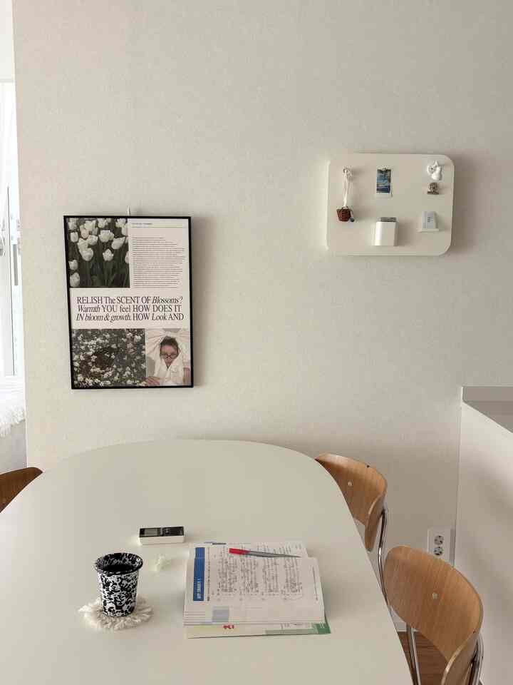 明るいホワイトと木目調の調和が取れたキッチン兼ダイニングスペース、シンプルで清潔感のあるデザインに学習資料が置かれた落ち着いた作業空間