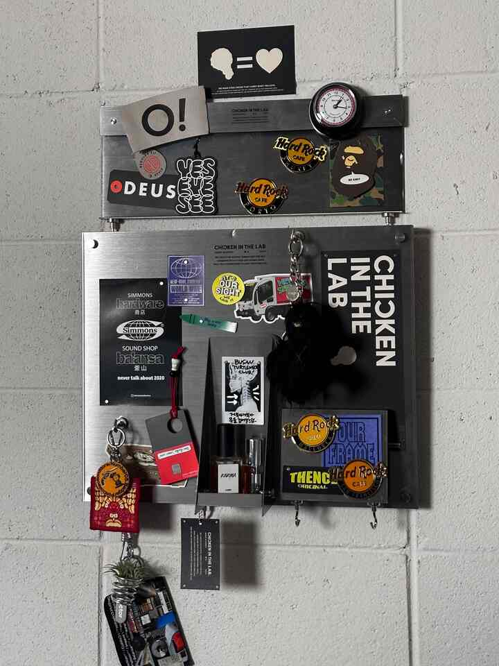 シルバーのステンレスボードが壁に取り付けられ、ウォールデコと収納アイデアが際立つ空間