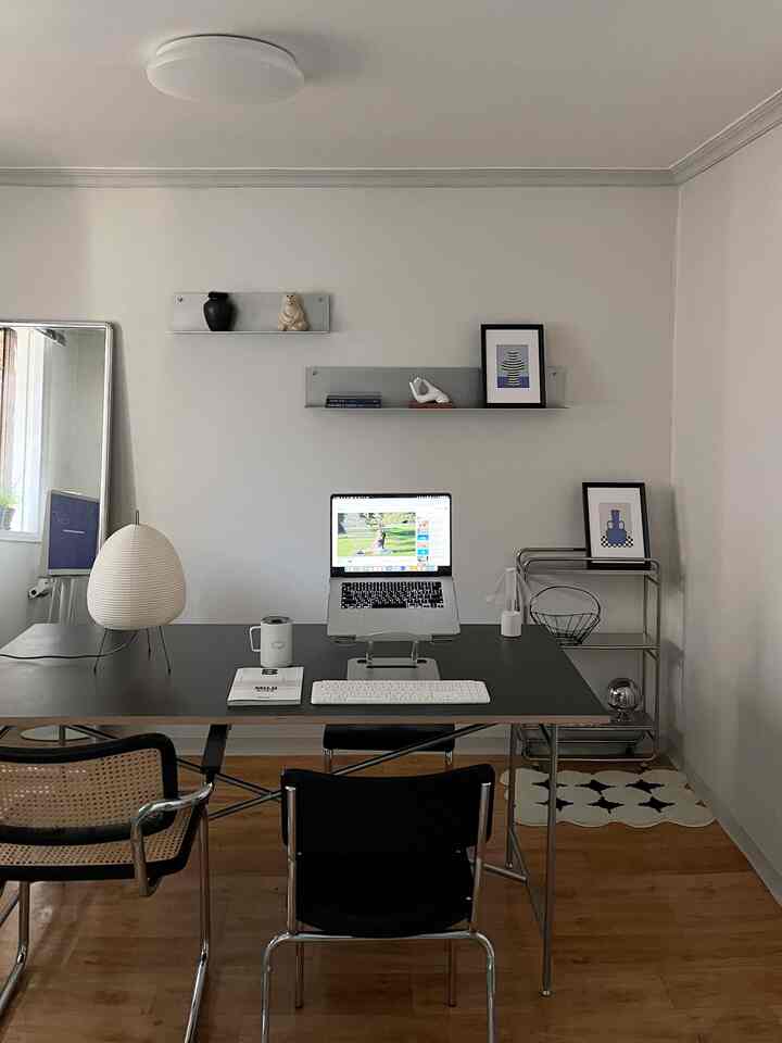 ナチュラルな木目調の床とモダンな家具が配置されたミニマルなホームオフィス空間