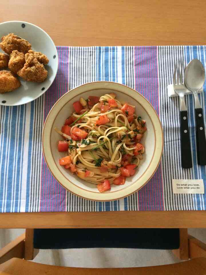 木目調のダイニングテーブルにパスタとフライドチキンが置かれたダイニングの雰囲気あるインテリア