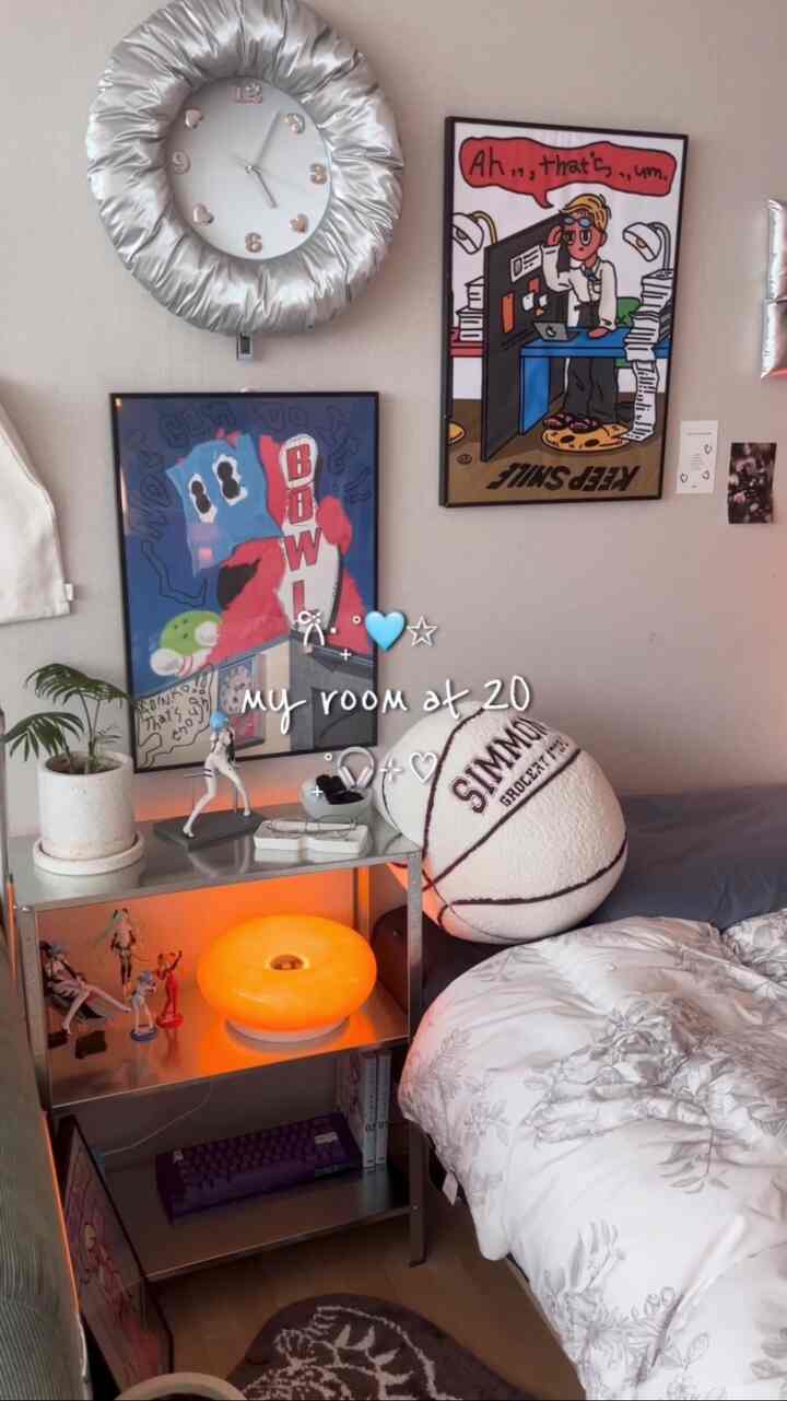 白とグレーのトーンのワンルーム寝室、フィギュアと額縁が配置された落ち着いた空間