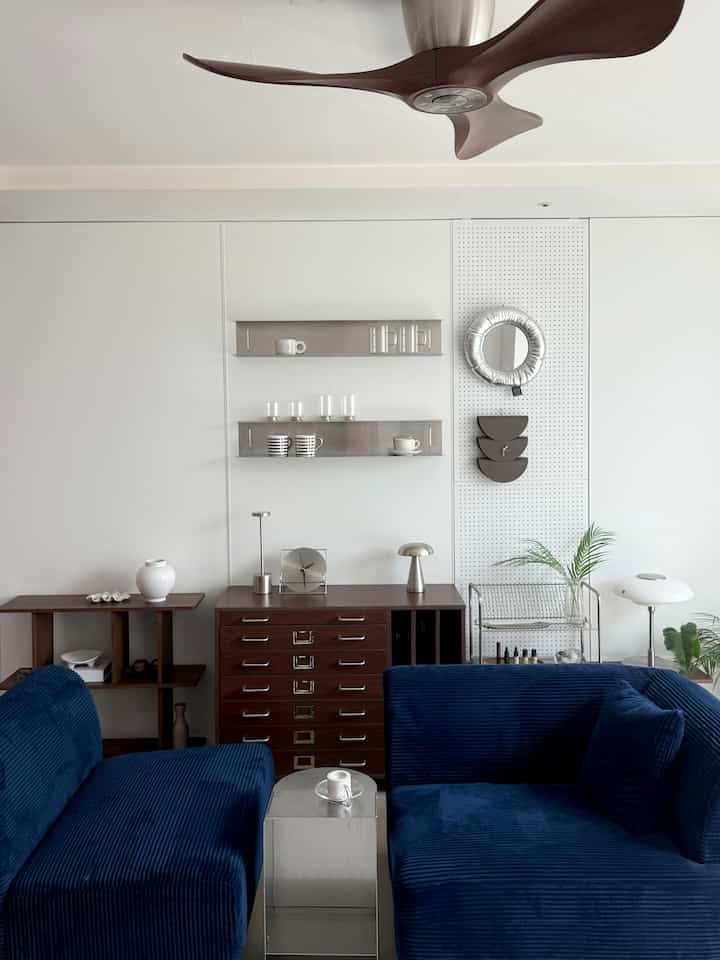 ネイビーのソファと白い壁、モダンな家具が配置されたリビング