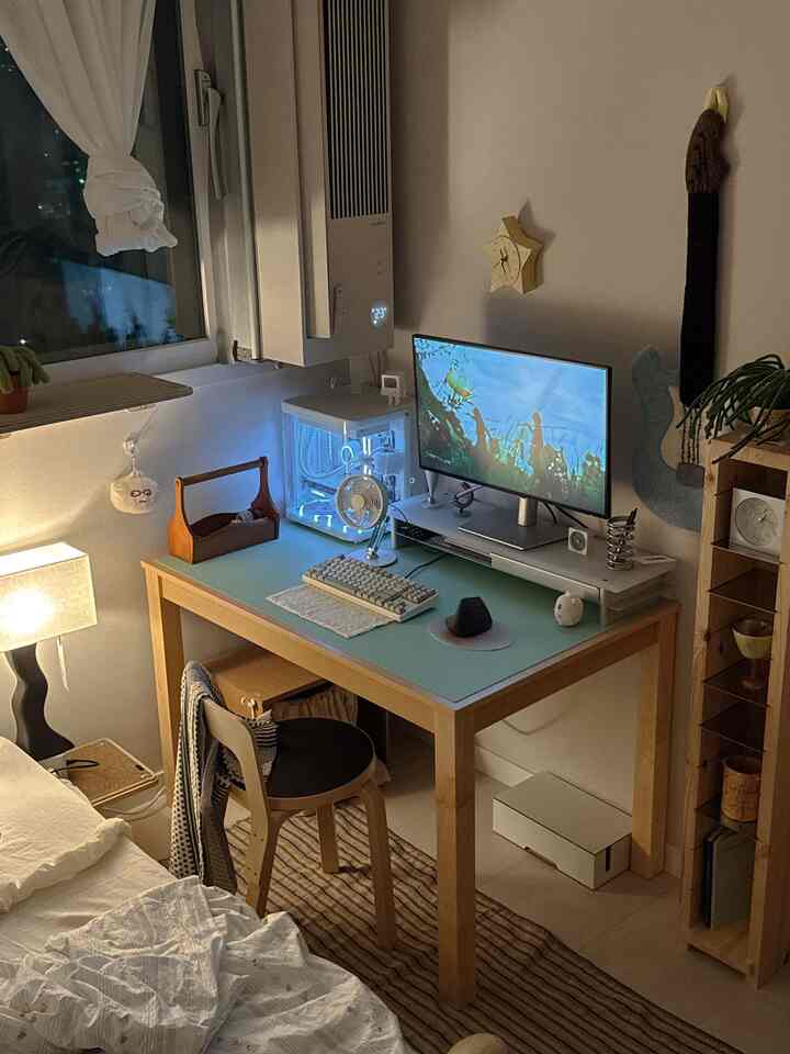 ナチュラルトーンのくつろげる一人暮らし用寝室兼ホームオフィス、モニターと整頓された家具が配置されたシンプルなインテリア