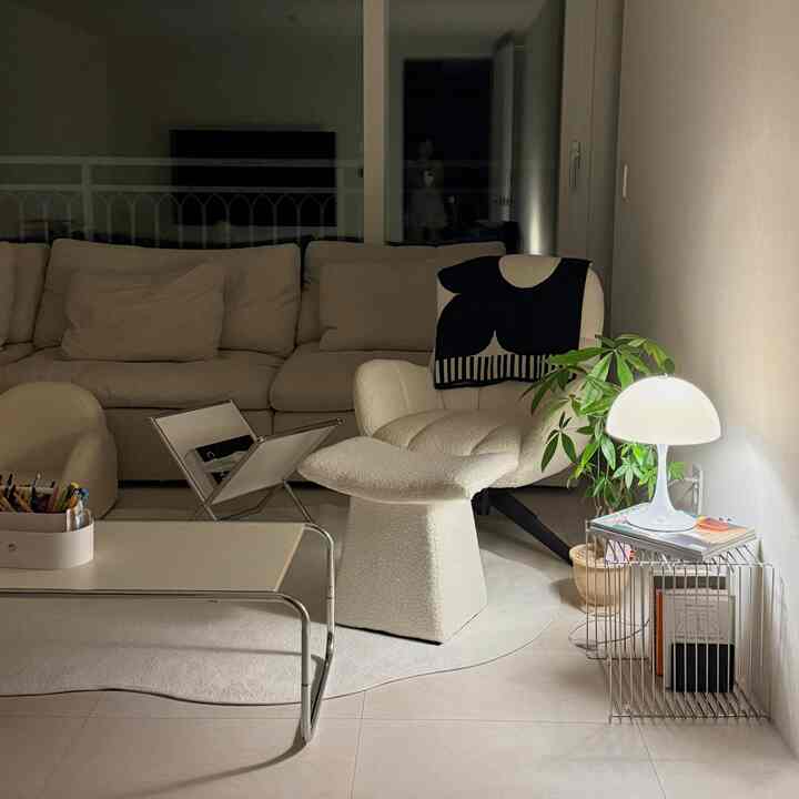 White and ivory toned living room featuring ivory sofa and armchair with ambient lighting in a cozy relaxation space