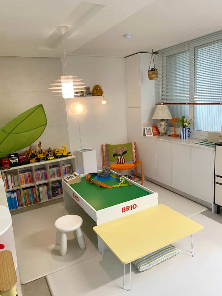 白を基調とした子供部屋、玩具と子供用家具が配置された明るく温かみのあるインテリア