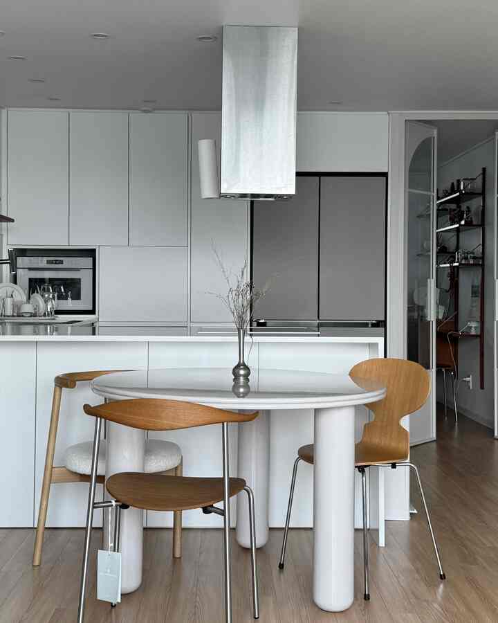 白と木目調が調和したキッチンとダイニングスペース、シンプルでモダンな雰囲気のインテリア