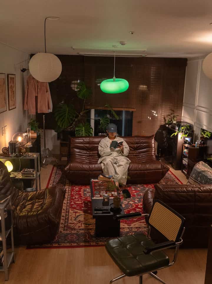 Cozy living room in natural tones featuring brown leather sofas and vintage patterned rug