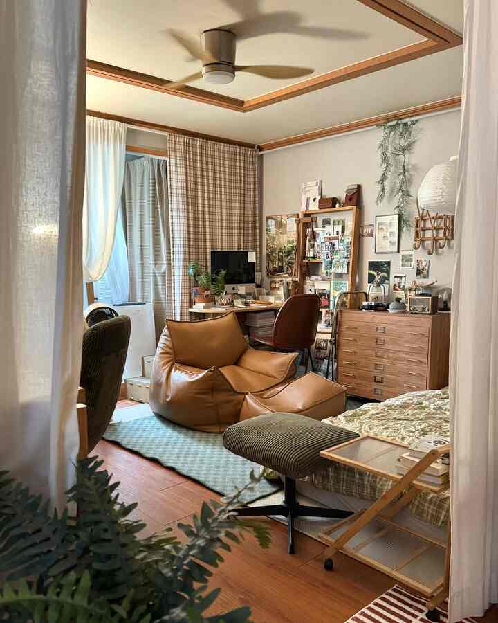 温かみのある木目調とブラウンのビーンバッグが印象的な居心地の良いリビング、ポスターや小物で彩られたコージーインテリア