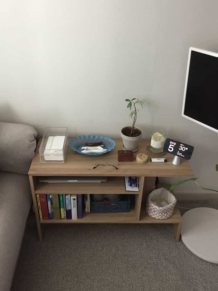 ナチュラルな木目調のリビング、本棚とソファが配置された落ち着いた空間