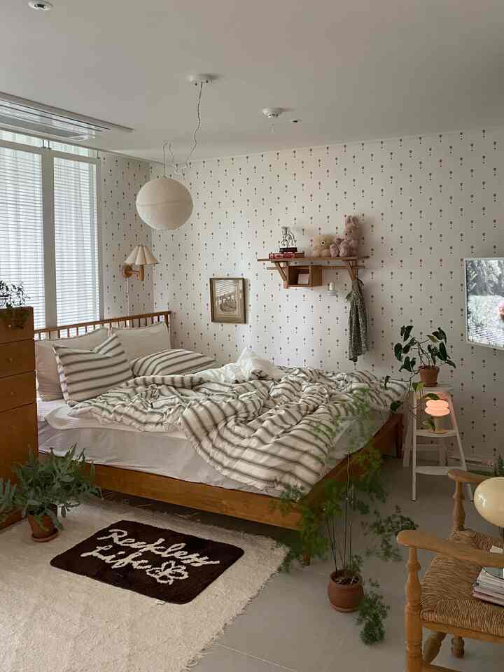 Vintage-inspired bedroom in white and brown wood tones, featuring a wooden bed and various plants creating a cozy atmosphere