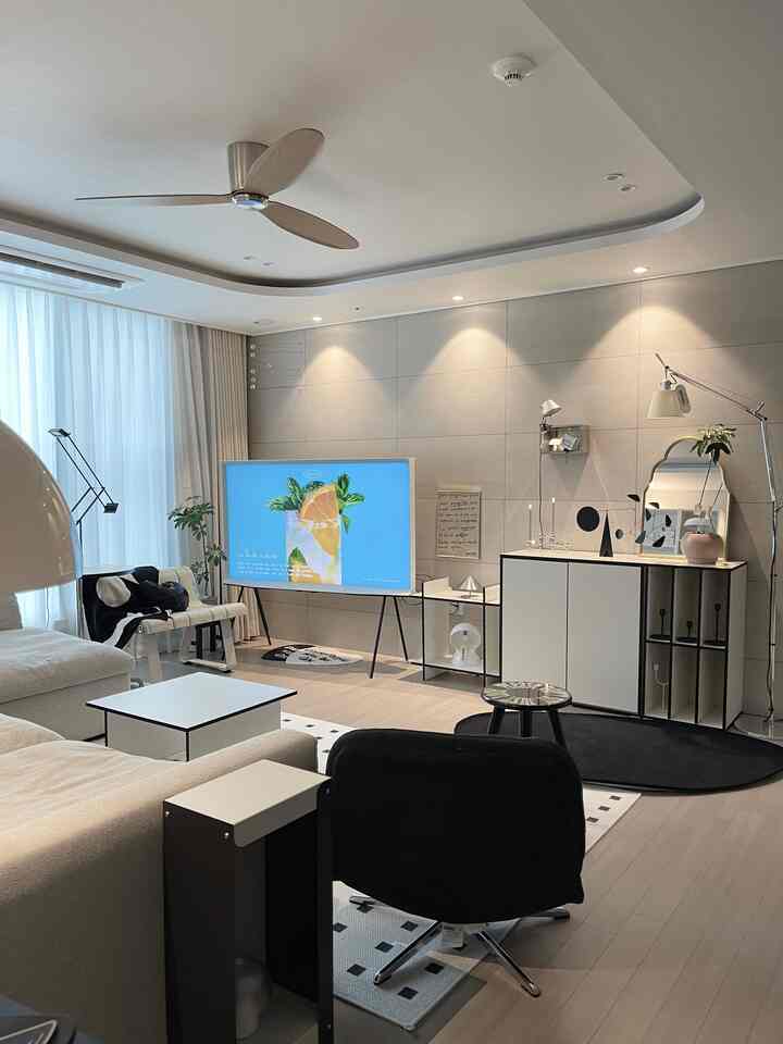 ナチュラルなウッドトーンと白が調和したモダンなリビング、ソファとテレビ台が配置された落ち着いた空間