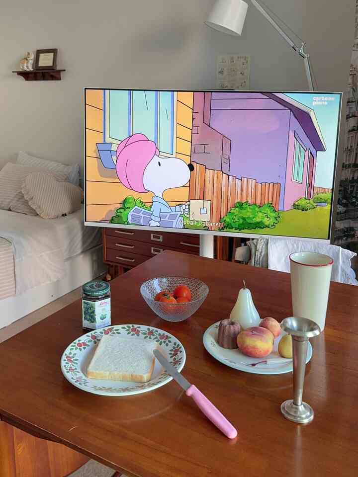 ナチュラルモダンな色調のリビング兼寝室、木目調のコーヒーテーブルと白いソファが配置された温かみのある空間