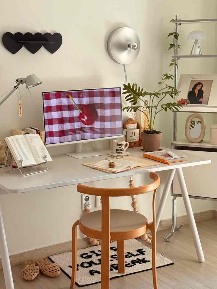 白とシルバーのトーンのホームオフィス、シンプルなデスクと木製チェア、モニターと壁照明が調和する清潔感のある空間