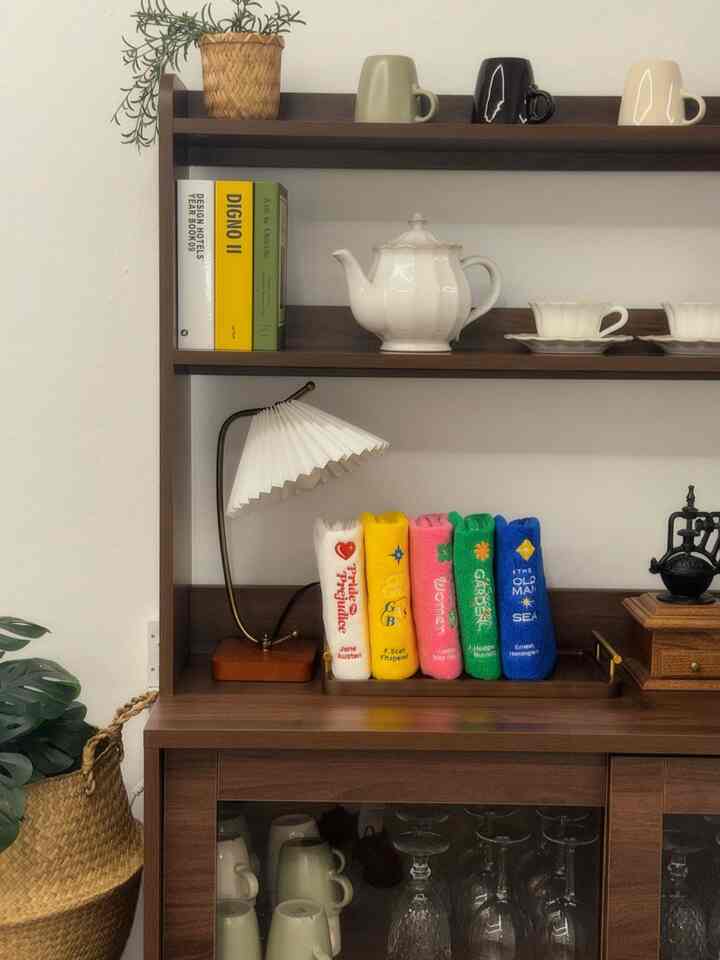 木目調の家具とカラフルなタオルが並ぶ、白い壁面の印象的なオブジェの空間