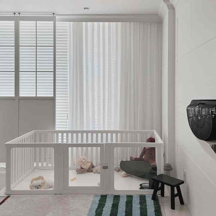 白を基調としたリビング、ペット用の遊び場やクッションが配置された明るく清潔感のあるインテリア