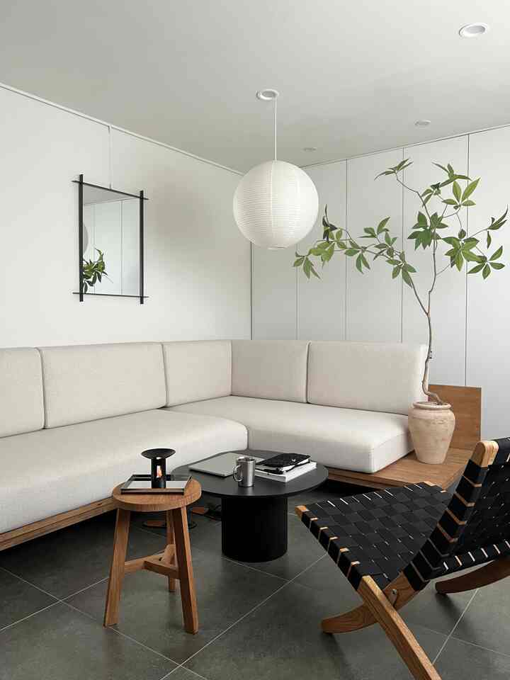 白とベージュのトーンのリビング、ベージュのソファと木目調家具が配置されたモダンで落ち着いた雰囲気のインテリア