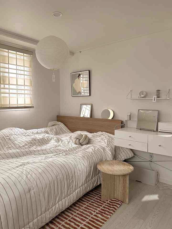 白と木目調が調和した二人暮らしの寝室、化粧台と壁棚が配置された自然な雰囲気のモダンなインテリア