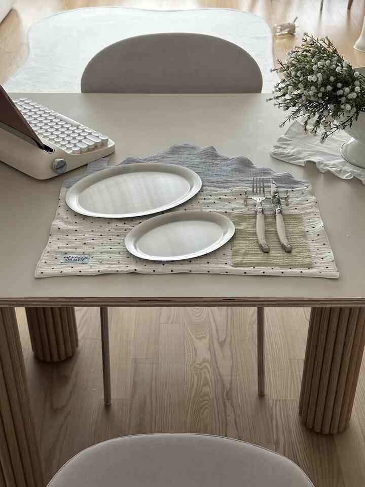 ホワイトとブラウンの色調のダイニングスペース、レトロなキーボードとカトラリーが配置されたシンプルなホームオフィス風インテリア