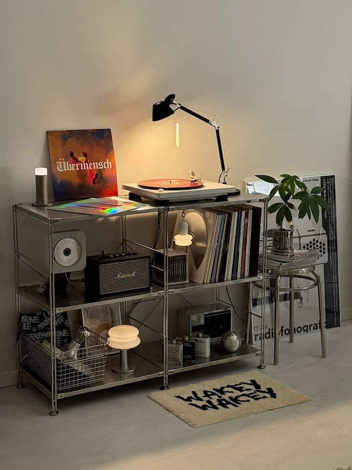 Warm toned music zone featuring stainless steel shelf with turntable, LPs, and desk lamp