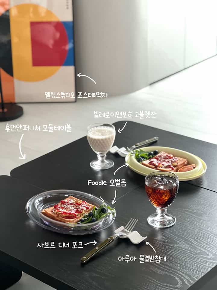 黒のモジュールテーブルにホームカフェの食器と透明なオーバルドームプレートを配したモダンでシンプルな空間