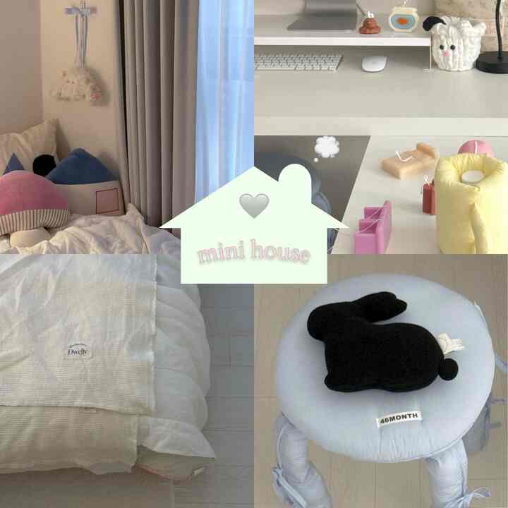 柔らかいベージュとホワイトのトーンのワンルーム、デスクと棚、クッションを置いたベッド、かわいい小物で飾られた居心地の良い空間