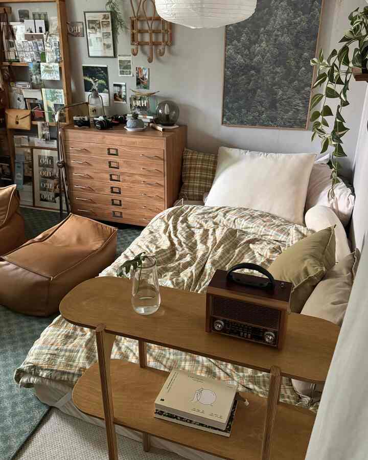 温かみのある木目調とグリーンが調和した寝室、棚とヴィンテージ小物が配置された雰囲気のあるインテリア