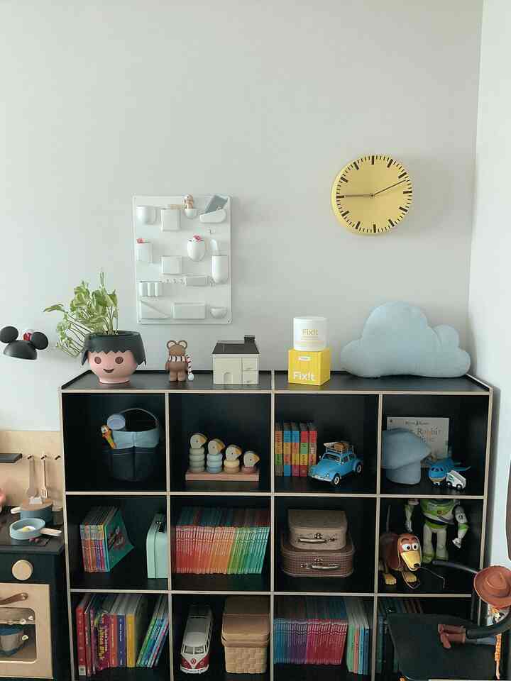 黄色と黒が調和した子供部屋、玩具や本が並ぶ本棚が配置された雰囲気のあるインテリア