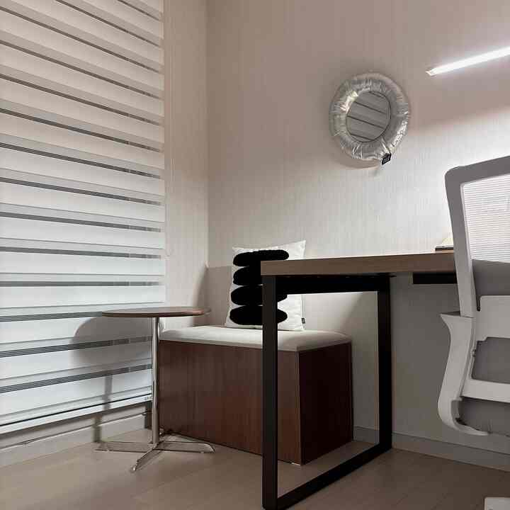 白と茶色のトーンでまとめられたホームオフィス、デスクとオフィスチェアが配置されたモダンで清潔感のあるインテリア