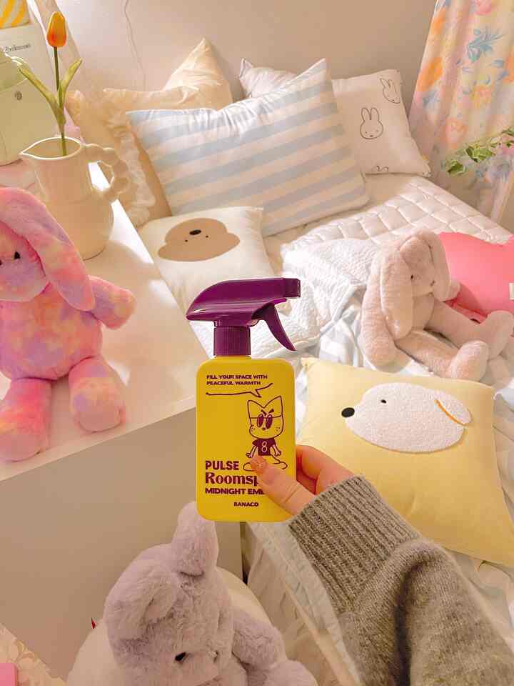 黄色と白を基調とした子供部屋の寝室、ぬいぐるみとかわいいクッションが配置された温かみのある空間