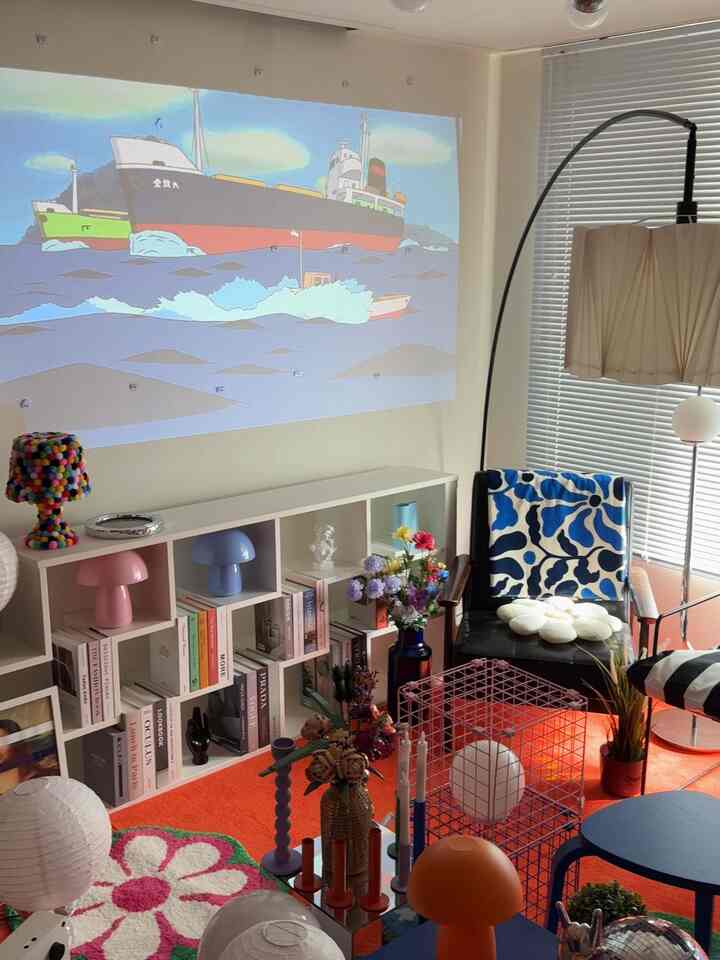 オレンジ色のラグとフロアランプがあるモダンでアールデコ調のリビングスペース