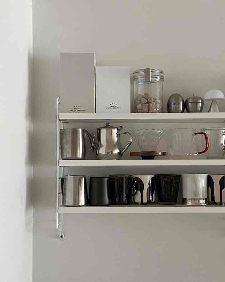 White walls and shelves organizing mid-century modern kitchenware in a clean kitchen space