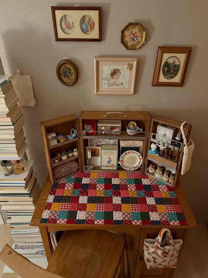 ナチュラルカラーと木目調の書斎、カラフルなテーブルランナーと額縁が配置された雰囲気のあるインテリア