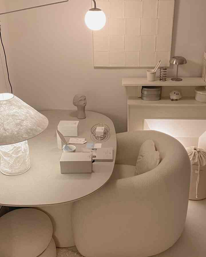 ベージュ調のコンパクトなリビング、丸いソファとテーブルランプが配置されたシンプルでナチュラルモダンな雰囲気のインテリア