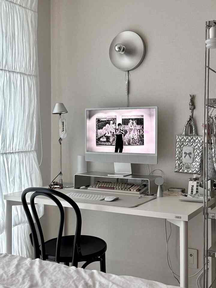 Silver and white toned home office featuring a central monitor and desk with subtle wall sconce, creating a modern atmosphere