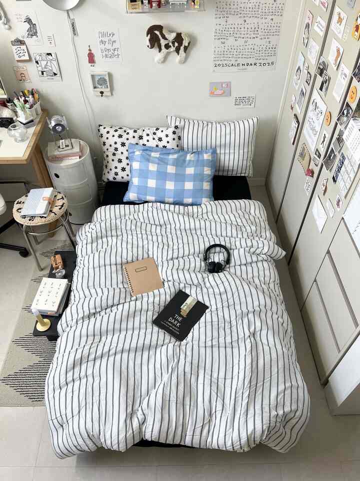 White and black toned small bedroom featuring striped bedding and built-in closet in a cozy setting