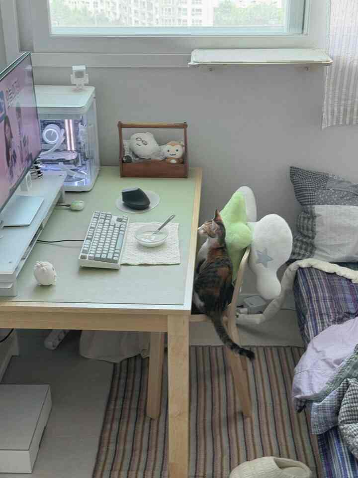 白とナチュラルカラーのホームオフィス空間、デスクの上にコンピューター機器と椅子に座る猫がいる暖かい雰囲気のインテリア