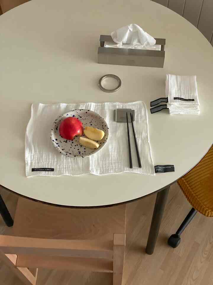 白を基調としたキッチンテーブル、キッチンクロスとランチョンマット、小皿と箸が置かれたシンプルな空間