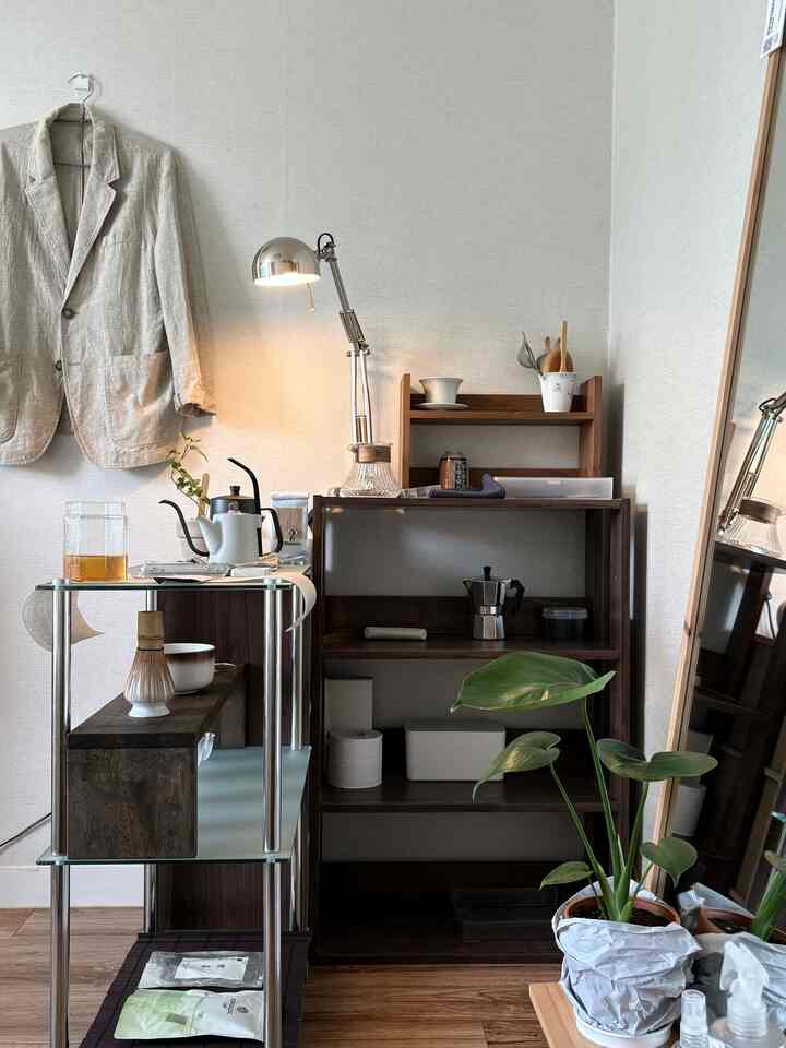 ナチュラルな木目調と白い壁が調和したおうちカフェ空間、コーヒーツールとシルバーのデスクランプが配置された雰囲気のあるインテリア