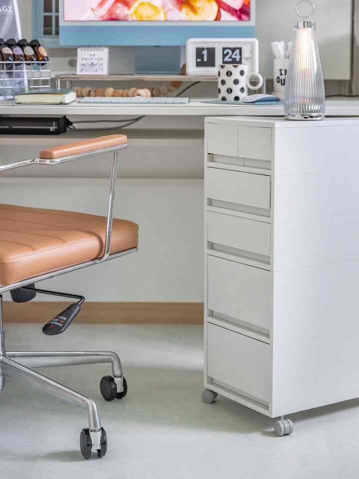 白を基調としたモダンなホームオフィス、ブラウンのオフィスチェアと白い収納キャビネットが配置された整理された作業空間