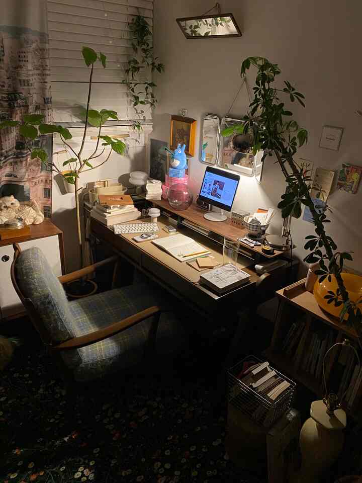 ナチュラルな木目調とグリーンの植物が調和した居心地の良いホームオフィス、木製のデスクとオフィスチェアが配置されたインテリア