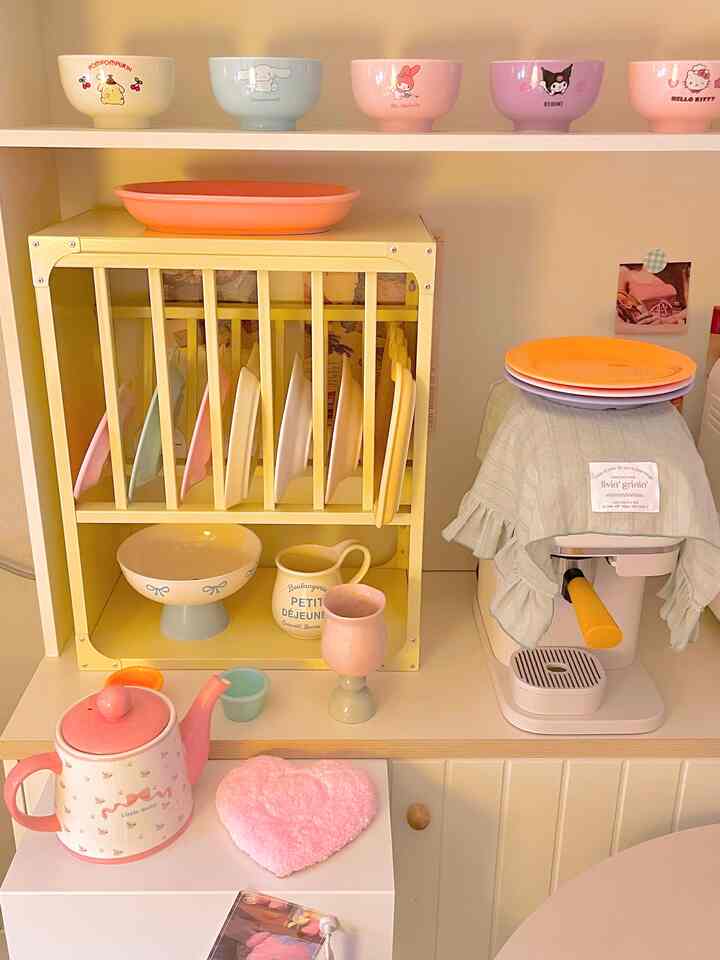A soft pastel-toned kitchen featuring organized dish racks and a coffee machine creating a cozy atmosphere