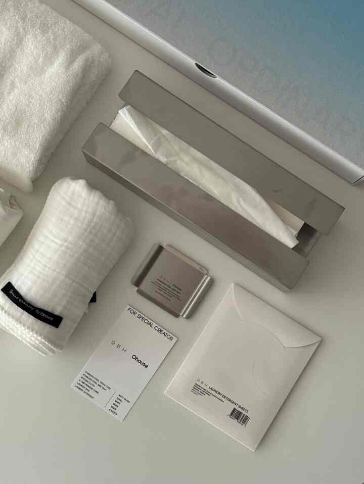 白とシルバーのトーンで整えられたミニマルな印象のバスルーム用品セットが配置された空間