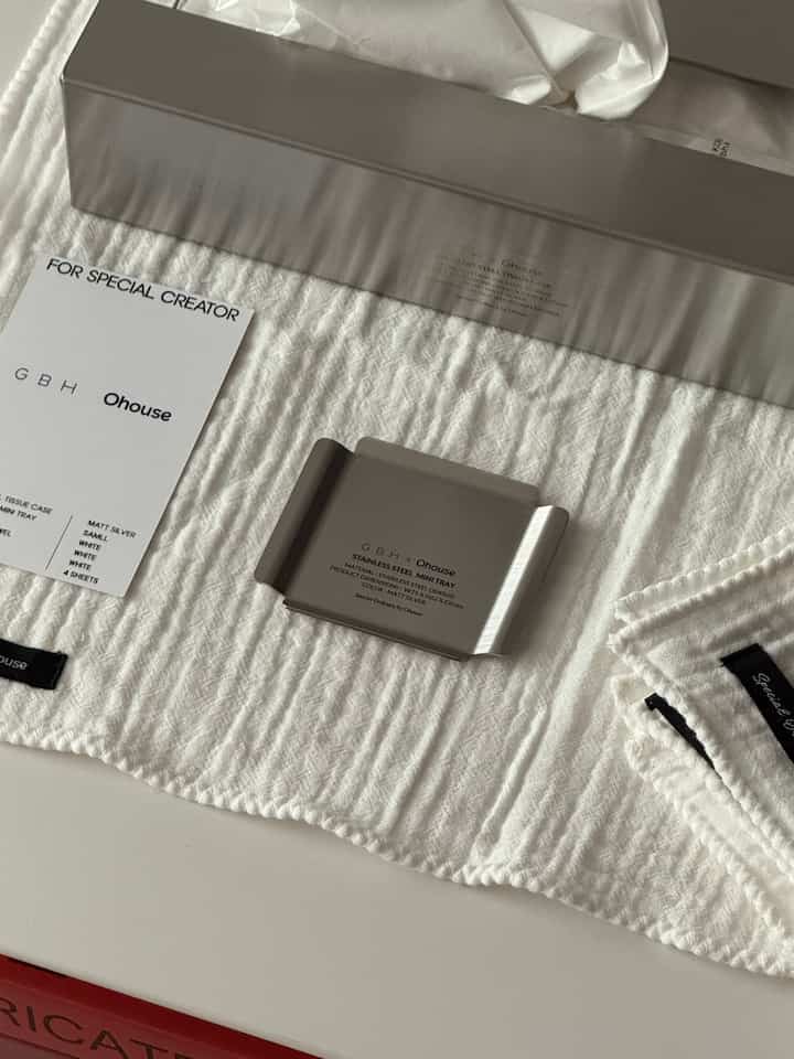 白い布の上にステンレス製のミニトレイとティッシュケースが配置されたミニマルなキッチン小物の写真