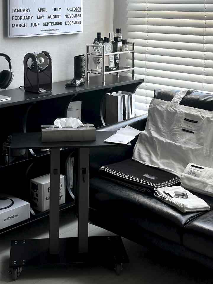 モノトーンのホームオフィス空間、黒いレザーソファとブラインド、多様なインテリア小物が配置された洗練された雰囲気のインテリア